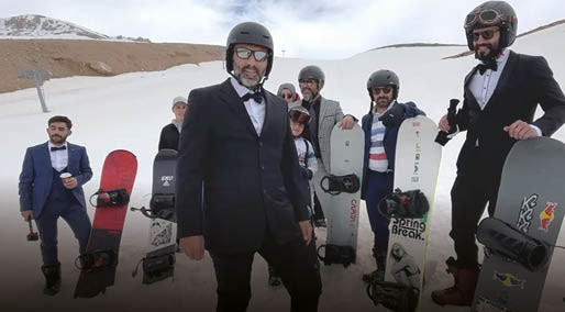 Takım elbise, kravat ve papyonla snowboard