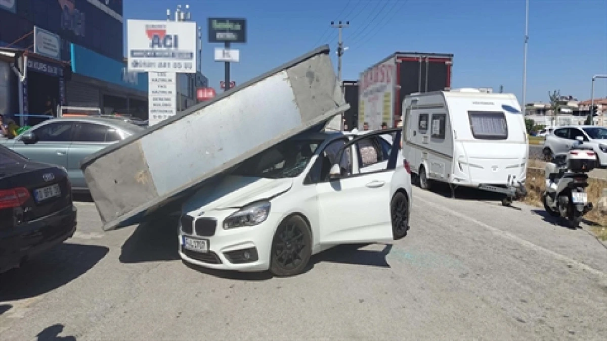 &Uuml;zerine reklam totemi devrilen otomobilin s&uuml;r&uuml;c&uuml;s&uuml; yara almadan kurtuldu